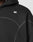 Close-up of the LFDY Active Fleece Hooded Zip by LIVE FAST DIE YOUNG in black, featuring an oversized fit, visible stitching, and a small white logo on the chest. The hood is up, showing part of the wearer’s shoulder, neck, and jawline.