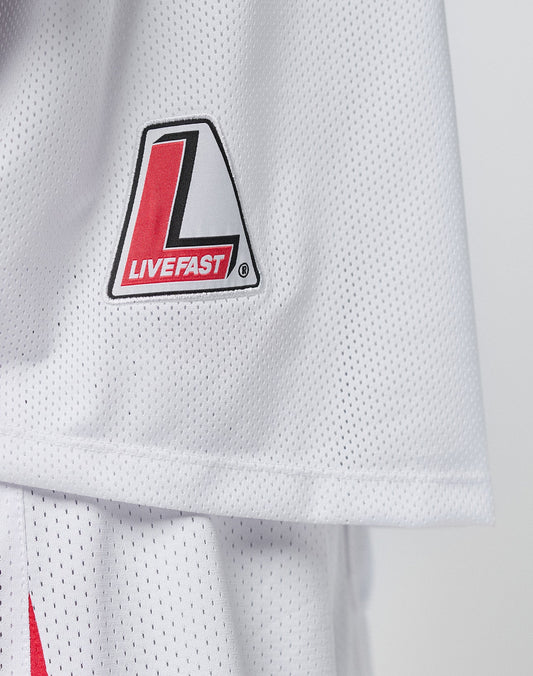 A close-up of the Basic Mesh Jersey by LIVE FAST DIE YOUNG, featuring a white mesh fabric, V-Ausschnitt, red and black L logo, and LIVE FAST text on the upper left. Made from 100% polyester with an oversize fit for comfort.