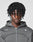 A young person with medium-dark skin and twist-styled hair faces the camera, wearing the LIVE FAST DIE YOUNG LFDY Active Fleece Hooded Zip in Oversize Fit with a white logo print on the chest, against a plain light background.