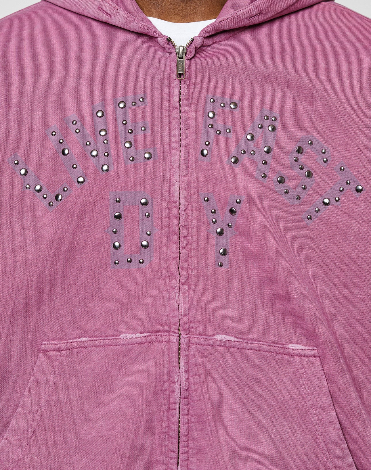 The Live Fast Rivet Hooded Zip by LIVE FAST DIE YOUNG is an oversize mauve zip-up hoodie with studs forming “LIVE FAST” and “D*Y S*”, visible stitching, and handgefertigter Sprayeffekt for a unique style.