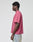 A man in profile faces left, wearing a LIVE FAST DIE YOUNG Live Fast LF Tee in mauve with an oversize fit and light blue jeans, standing against a plain light gray background.