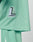 A close-up of the mint green Basic Mesh Jersey by LIVE FAST DIE YOUNG, featuring 100% polyester mesh and a patch with a large L and LIVEFAST. Matching shorts with a white stripe and contrast piping are partially visible.