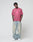 A person stands against a plain background, hands in pockets, wearing the LIVE FAST DIE YOUNG Live Fast LF Tee (oversize fit, pink, front print, 100% Baumwolle) with baggy faded blue jeans and white sneakers for a relaxed look.
