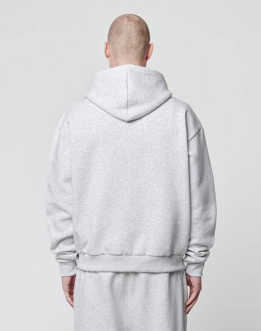 A person with a shaved head, seen from behind, wears an oversize fit light gray LIVE FAST DIE YOUNG Basic Blank Hooded sweatshirt and matching sweatpants made of soft Baumwolle against a plain light background.