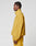 A man in profile wears the LIVE FAST DIE YOUNG LFDY Trackjacket, an oversized mustard yellow polyester jacket with a high collar and elastic cuffs, paired with matching pants, set against a plain white background.