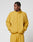 A man wearing the LIVE FAST DIE YOUNG LFDY Trackjacket in yellow with matching oversized pants stands with his hands in his pockets, looking to the side against a plain white background.