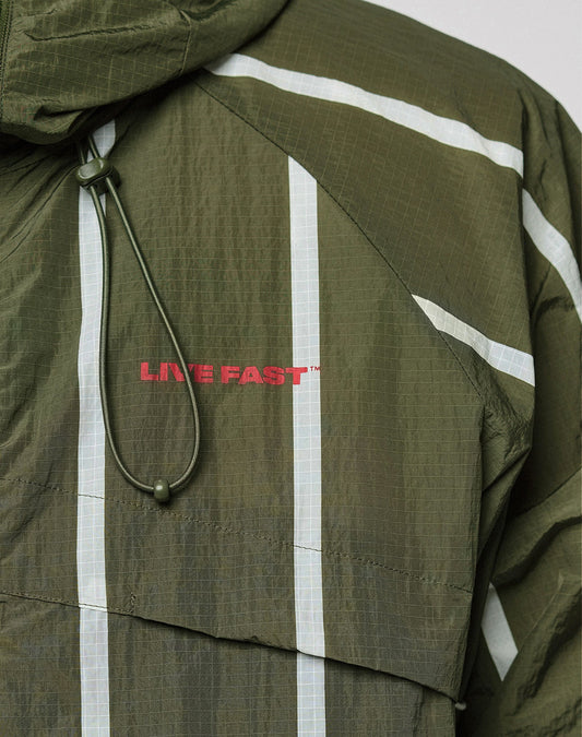 The LFDY Nylon Trackjacket by LIVE FAST DIE YOUNG is an olive green, oversize-fit jacket featuring reflective white stripes, a hood with elastic drawstring, and bold red LIVE FAST™ prints on the front and back.