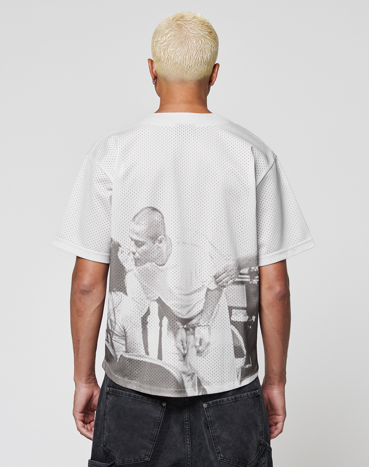 A person with short bleached blonde hair, facing away, wears the LIVE FAST DIE YOUNG LFDY Courtroom Jersey featuring a bold black-and-white graphic on the back and dark shorts.