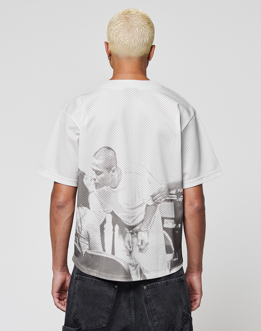 A person with short bleached blonde hair, facing away, wears the LIVE FAST DIE YOUNG LFDY Courtroom Jersey featuring a bold black-and-white graphic on the back and dark shorts.
