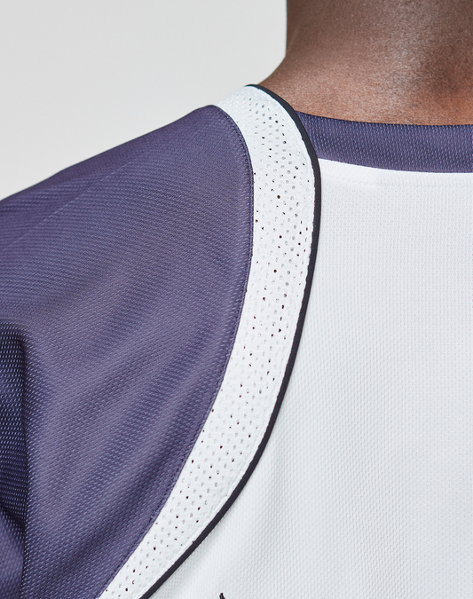 Close-up of a person wearing the LFDY Call Us Jersey by LIVE FAST DIE YOUNG, featuring dark purple and white polyester mesh, black trim, and a V-Ausschnitt neckline. The oversize fit emphasizes the unique texture and stitching details.
