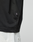 Close-up of a person wearing the LFDY Real Ones Tee by LIVE FAST DIE YOUNG in black, made from 100% Baumwolle, paired with light pants. The lower shirt features a small black tag with white text against a plain background.