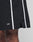 Close-up of a person wearing Basic Cotton Shorts by LIVE FAST DIE YOUNG, featuring a regular fit, black color with white vertical stripes, elastic waistband, front slit, and white LFDY logo print near the above-the-knee hem.