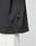 Close-up of the lower side of the LFDY Grand Theft Tee by LIVE FAST DIE YOUNG, featuring a small “FRGMT” fabric tag at the hem, styled with white pants. Focus is on the shirt’s hem and side seam.