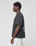 A man with short curly hair stands in profile, wearing the LIVE FAST DIE YOUNG LFDY Grand Theft Tee featuring front and back prints and light-colored shorts against a plain white background.