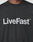 A person wears the Basic LiveFast Tee by LIVE FAST DIE YOUNG, a black regular-fit cotton T-shirt with a bold LiveFast™ front print in large white letters across the chest.