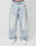 A person wears LFDY Baggy Denim by LIVE FAST DIE YOUNG—loose, light-wash blue jeans with a wide straight leg in 100% cotton. Only the lower torso and legs are shown, paired with white sneakers against a plain white background.