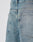 Close-up of the back of LIVE FAST DIE YOUNG LFDY Tire Tracks Jorts, showing baggy light blue denim, two rear pockets, visible stitching, and a small black fabric tag by the right pocket seam.