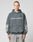 A person wearing the LFDY Window Hooded by LIVE FAST DIE YOUNG, a dark gray oversized hoodie made of 100% Baumwolle with a reflektierender LIVE FAST Frontprint and sleeve graphics, stands against a plain light gray background.