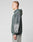 Wearing the LFDY Window Hooded by LIVE FAST DIE YOUNG in an oversize faded green fit with reflective front print and graphic sleeves, a person pairs it with light gray jeans, standing in profile against a plain light background.