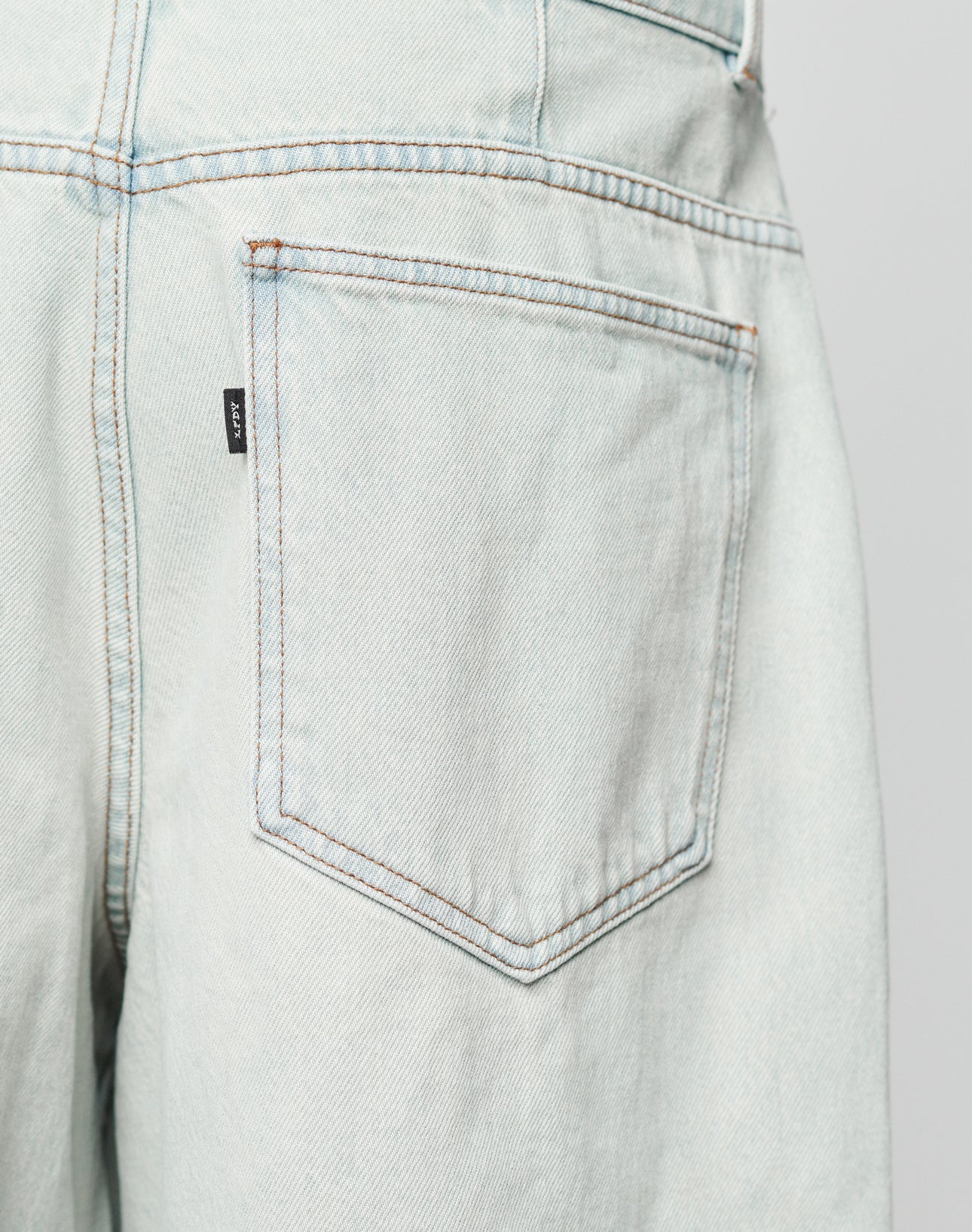 Close-up of the Gesäßtasche on LIVE FAST DIE YOUNG’s LFDY Jorts—baggy fit, light blue denim jeans featuring visible stitching and a small black tag on the pocket seam.