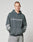 A young man with short hair wears the LFDY Window Hooded by LIVE FAST DIE YOUNG, a faded dark oversized hoodie in 100% Baumwolle with bold LIVE FAST reflective front print and sleeve graphics, standing against a plain light background.
