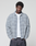 A person wearing an oversized Vintage Flannel by LIVE FAST DIE YOUNG in light gray plaid over a white t-shirt stands with hands in pockets against a plain light background, looking directly at the camera.