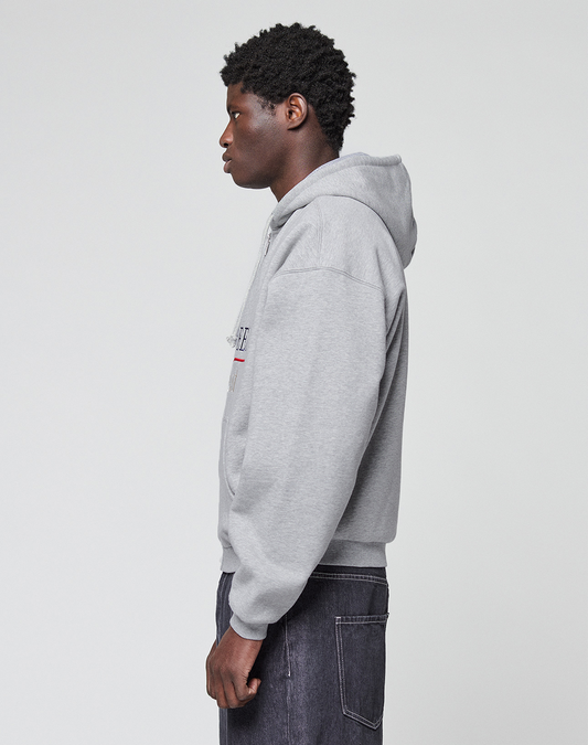 A person stands in profile against a plain background, wearing a light gray LIVE FAST DIE YOUNG Flannel Lined Hooded Jacket and dark jeans. Their hands rest by their sides as they look straight ahead.