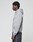 A person stands in profile against a plain background, wearing a light gray LIVE FAST DIE YOUNG Flannel Lined Hooded Jacket and dark jeans. Their hands rest by their sides as they look straight ahead.