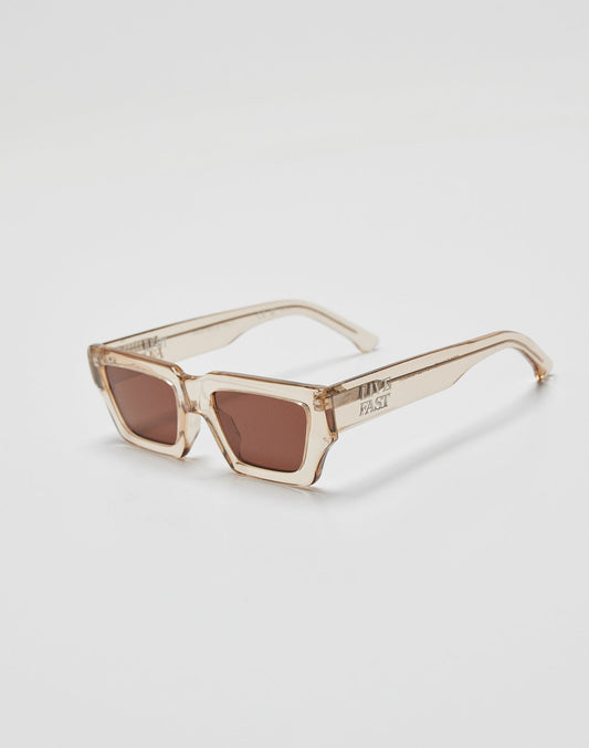 The Live Fast Sunglasses by LIVE FAST DIE YOUNG feature thick, translucent beige Mazzuchelli Acetate rectangular frames, brown-tinted lenses, and a silver logo for superior UV protection. Displayed on a white surface.