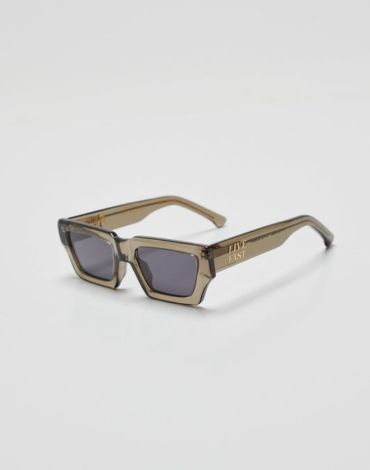 Live Fast Sunglasses by LIVE FAST DIE YOUNG feature thick, translucent brown Mazzuchelli Acetate rectangular frames with dark lenses and a gold-colored LIVE FAST logo on the left temple arm, shown on a white background.