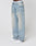 A person wears LFDY Baggy Denim by LIVE FAST DIE YOUNG—light-wash, subtly distressed jeans—with white sneakers and a white waistband featuring LIVE FAST branding, standing against a plain white background.