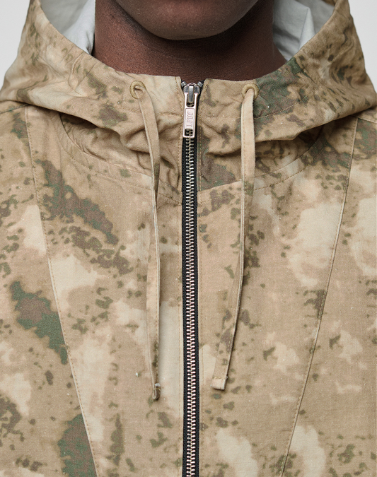 Close-up of a person wearing the LIVE FAST DIE YOUNG LFDY Camo Halfzip Jacket in an oversize fit, featuring a tan and green camouflage pattern and silver zipper, shown from shoulders to chin.