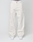 A model wears LIVE FAST DIE YOUNG Worker Pants—loose-fitting, off-white with a baggy fit, carpenter pocket, and branded white waistband—paired with white sneakers against a plain light background.