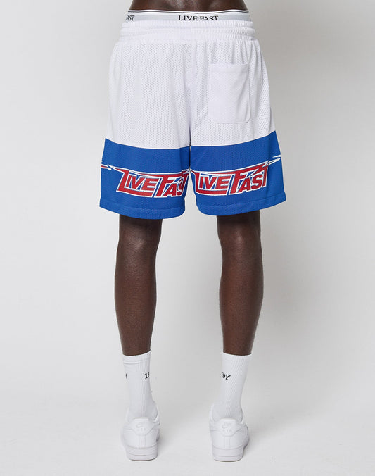 A person stands backward, wearing LIVE FAST DIE YOUNG LFDY Racing Mesh Shorts with blue stripes and red text, featuring großflächige Prints, paired with white socks and slides against a plain white background.