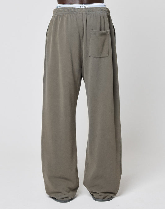 The LFDY Ripped Sweatpants by LIVE FAST DIE YOUNG are wide-fit, loose gray sweatpants made from 100% Baumwolle, with an Elastikbund, side and back pockets, plus a visible branded waistband, shown against a plain white background.