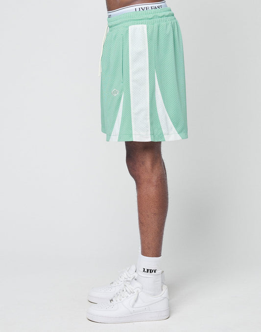 A person stands sideways wearing mint green LIVE FAST DIE YOUNG Striped Mesh Shorts with white accents, white socks, and white sneakers against a plain light background. The shorts feature a LIVE FAST waistband and subtle logo patch.