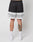 A person stands facing away in LIVE FAST DIE YOUNGs LFDY Racing Mesh Shorts, featuring black and white polyester mesh with LIVE FAST on the back. They wear white socks, white sneakers, and a colorful tattoo is visible on their left calf against a plain background.