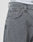 Close-up of a person wearing LFDY Baggy Denim jeans by LIVE FAST DIE YOUNG in light gray with baggy fit, straight leg, small front pocket, belt loops, silver D-ring, and white underwear waistband with black text peeking above.