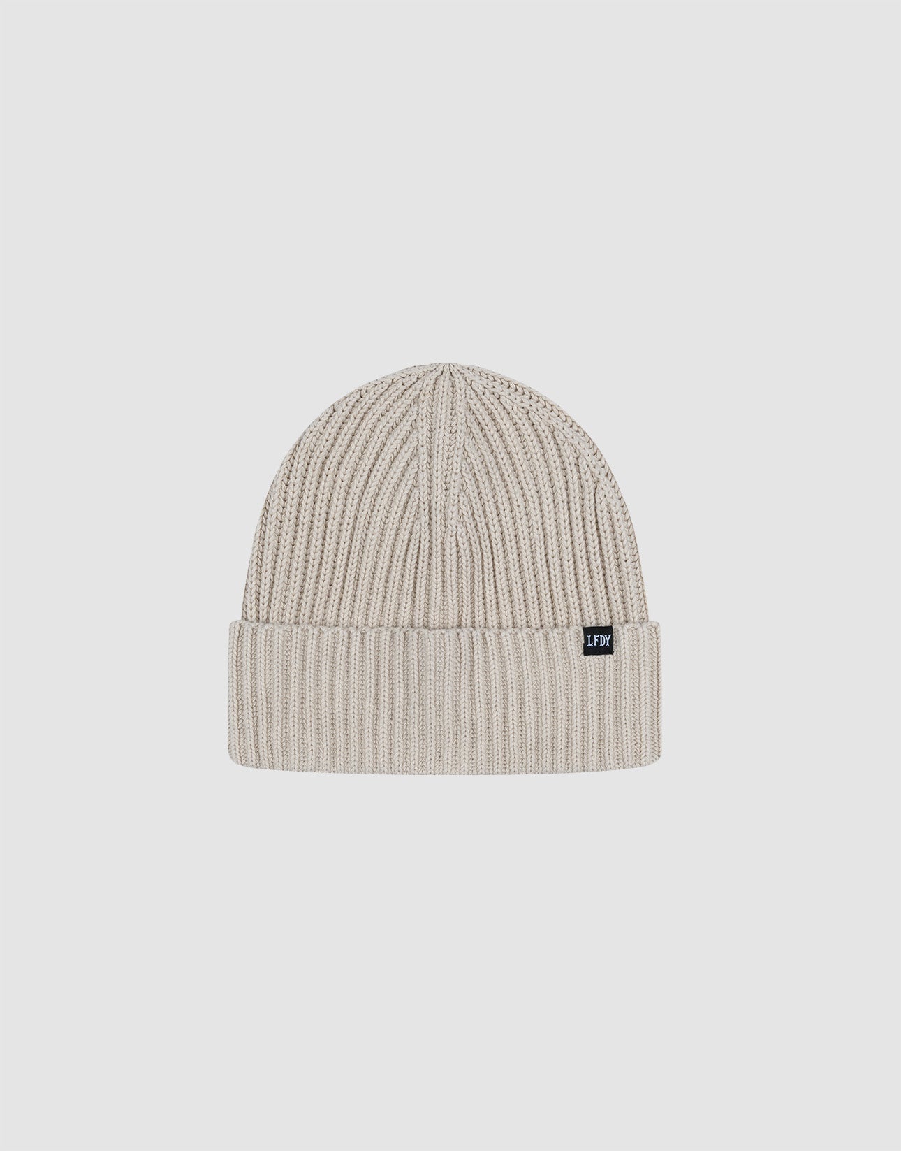 The LIVE FAST DIE YOUNG Double Rib Knit Beanie in light beige features a folded brim, double-layer ribbed construction for a voluminous look, and a small black rectangular tag on the cuff, shown against a plain white background.| plain