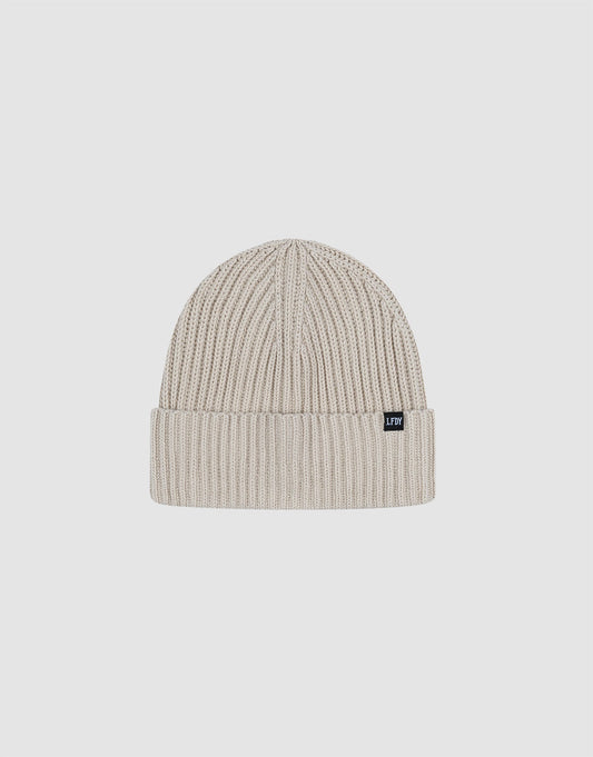 The LIVE FAST DIE YOUNG Double Rib Knit Beanie in light beige features a folded brim, double-layer ribbed construction for a voluminous look, and a small black rectangular tag on the cuff, shown against a plain white background.