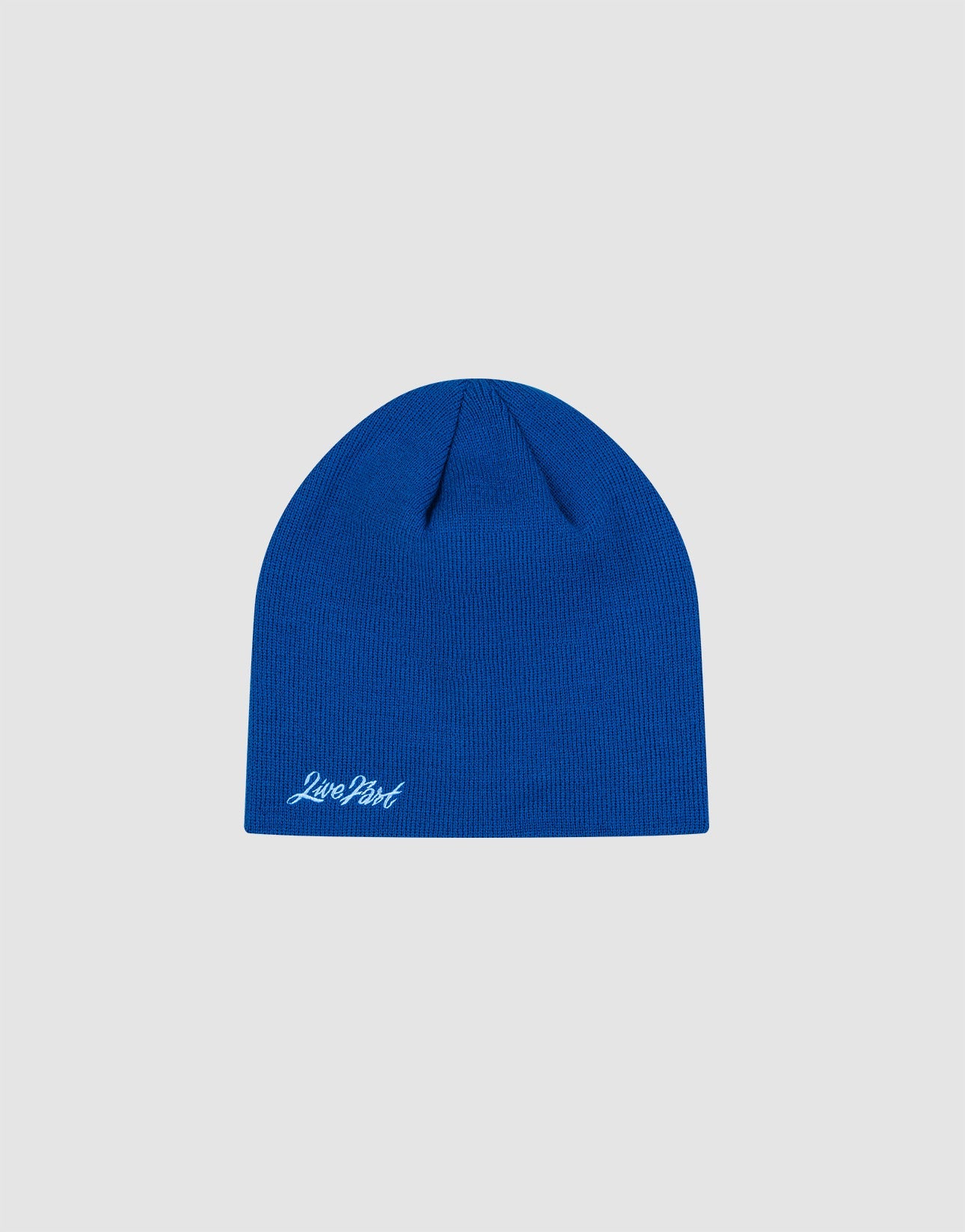 The LIVE FAST DIE YOUNG Script Beanie is a plain blue polyacryl knit hat in One Size, featuring a small white “Logo-Stick” script near the bottom edge, shown on a light gray background.