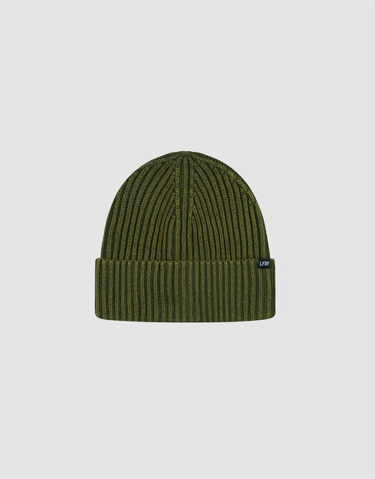 The LIVE FAST DIE YOUNG Washed Rib Knit Beanie in olive green Baumwolle features a folded brim and a small black flag label with white text, showcased on a plain light gray background.| plain 
