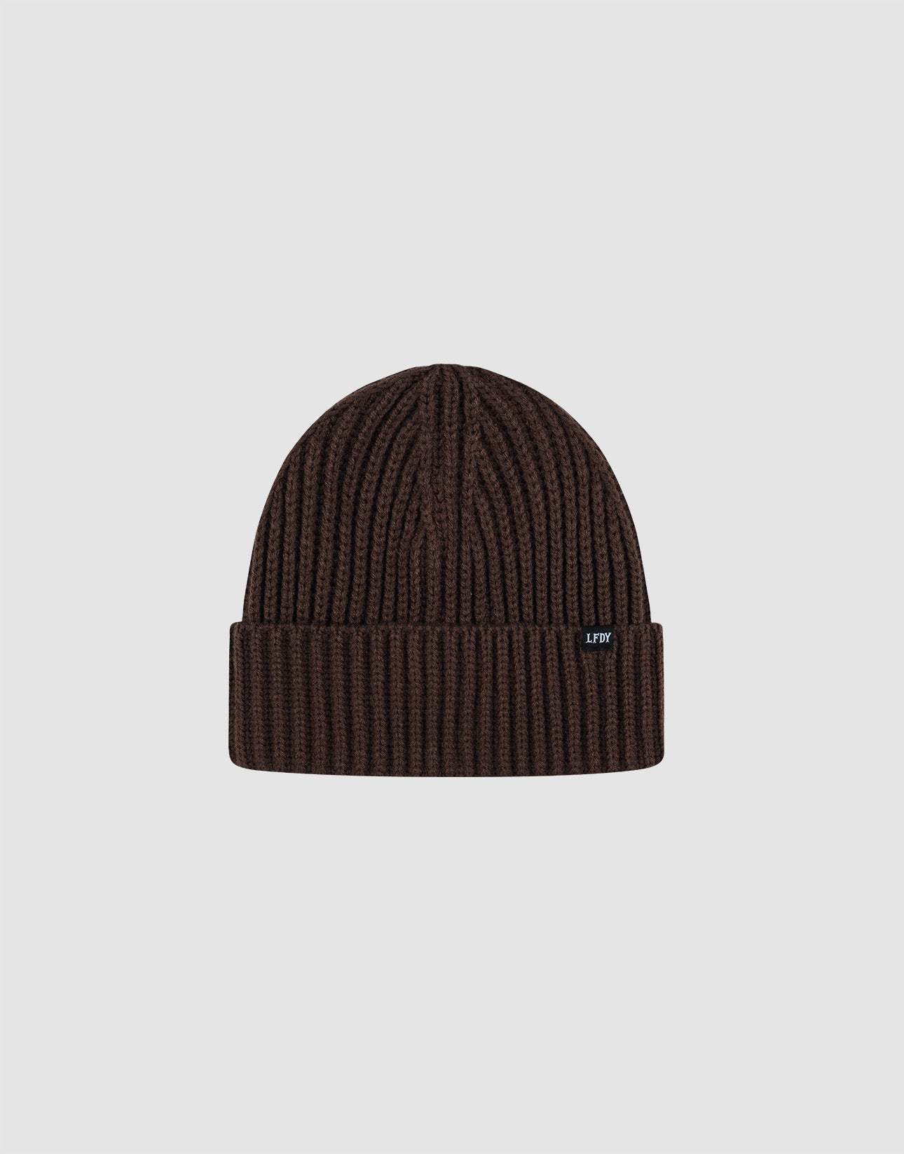 A dark brown Rib Knit Beanie by LIVE FAST DIE YOUNG in polyacryl with a folded cuff, shown on a light gray background. Features a small black tag with white text on the cuff. One Size for versatile wear.| plain 