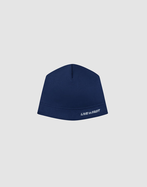 The Live Fast Performance Beanie by LIVE FAST DIE YOUNG is a blue fitted hat with "LIVE FAST" embroidered in white on the lower right and features a thin fleece lining, shown against a plain light gray background. 