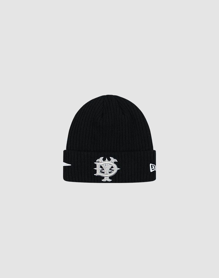 The LFDY x New Era Beanie by LIVE FAST DIE YOUNG is a black ribbed knit beanie with a folded brim, embroidered silver and white face logo, and New Era Flag on the front. Shown against a light gray background. 