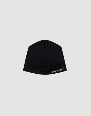 The Live Fast Performance Beanie by LIVE FAST DIE YOUNG is a fitted black beanie with a thin fleece lining and "LIVE FAST" in white on the lower right, shown against a plain light gray background. 