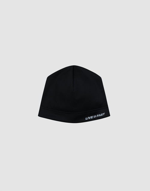 The Live Fast Performance Beanie by LIVE FAST DIE YOUNG is a fitted black beanie with a thin fleece lining and "LIVE FAST" in white on the lower right, shown against a plain light gray background. 