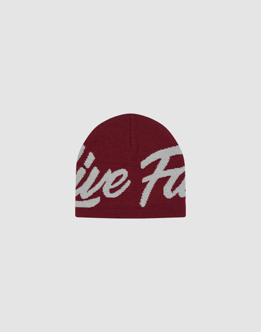 The LFDY Jacquard Beanie by LIVE FAST DIE YOUNG is a maroon polyamide knit hat with bold white Logo Strick script lettering across the front, shown on a plain light gray background.| plain 