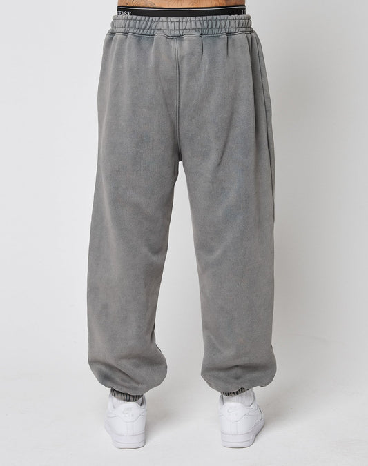 Model wearing LIVE FAST DIE YOUNG LFDY Europe Run Jogger—loose-fitting, elastic cuffed pants with vintage wash—paired with white sneakers, standing against a plain white background.