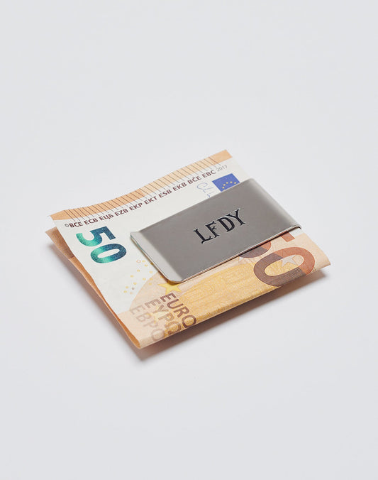 A Basic Money Clip aus Edelstahl von LIVE FAST DIE YOUNG hält gefaltete 50- und 20-Euro-Scheine auf weißem Hintergrund. Modell: LF2305-13597.